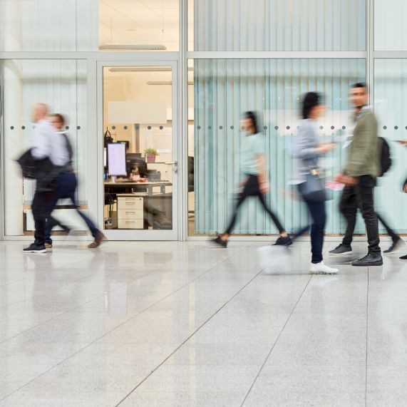 たくさんの人がオフィス内を歩いている